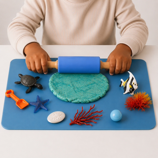 A child rolling playdough flat with the blue silicone rolling pin