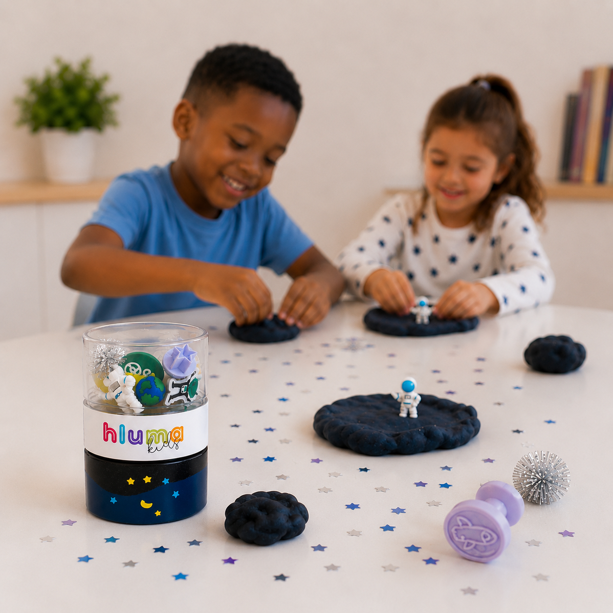 A boy and girl moulding dark sensory playdough with an astronaut figure from the Hluma Kids Cosmic Quest Wonder Jar