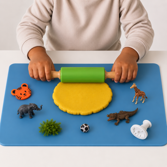 A child rolling playdough flat with the green silicone rolling pin